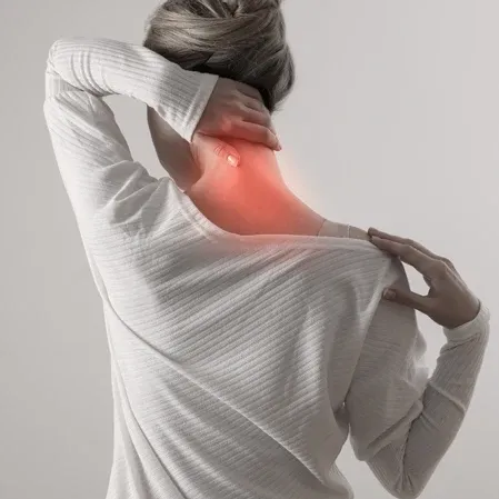 Person holding the back of the neck, with a red highlighted area extending across the neck and upper back.